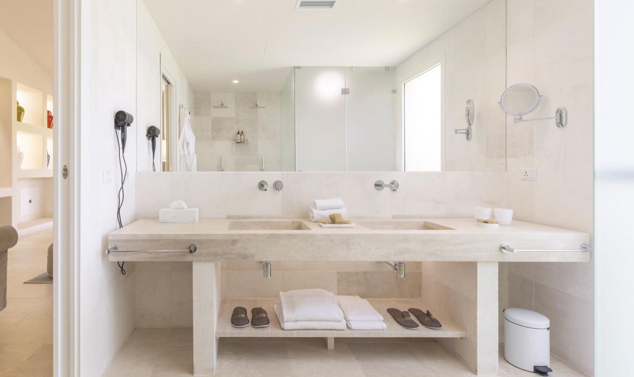 Bagno moderno con doccia, piastrelle blu e porta di legno.